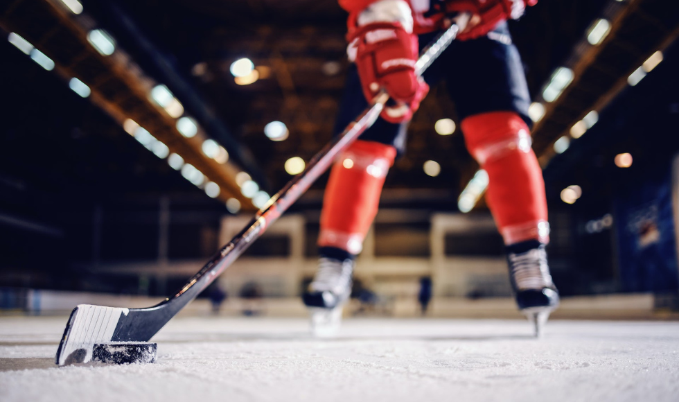 Hockey player holding a stick with a hockey puck