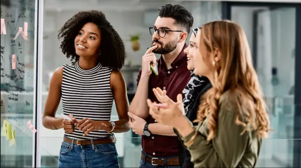 four people at work brainstorming together